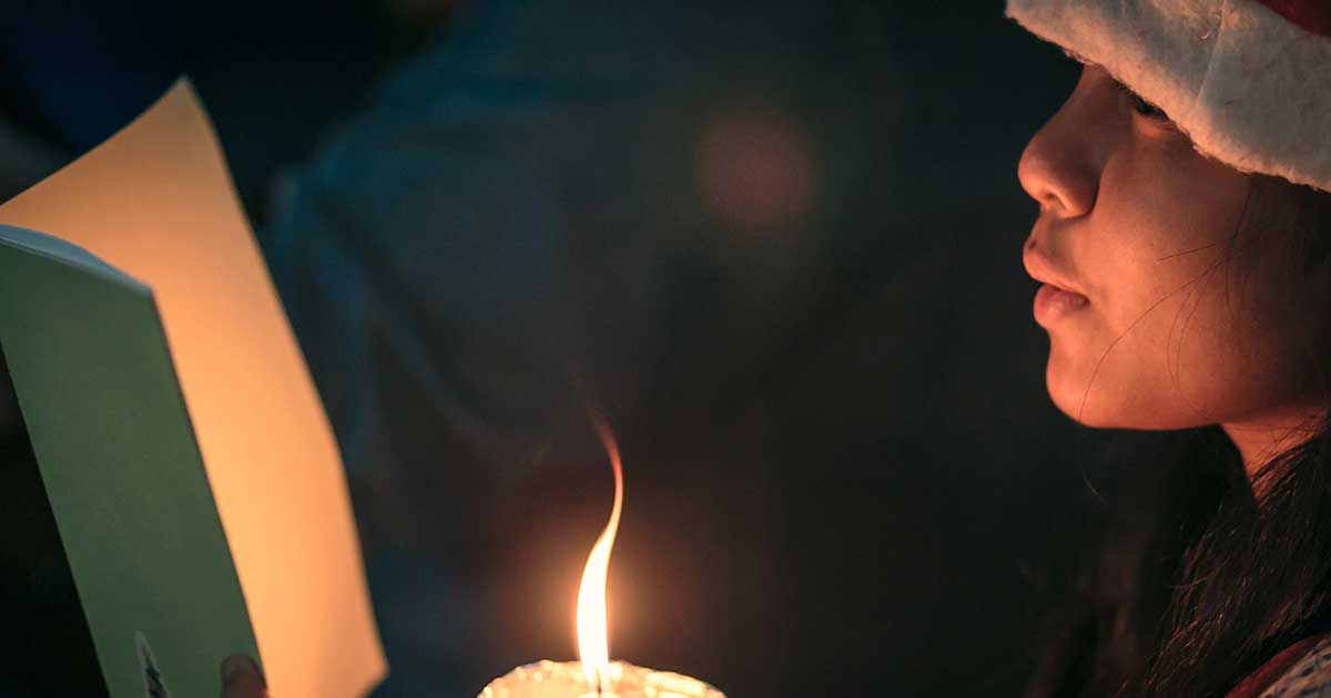 Christmas Carol singer with book and candle